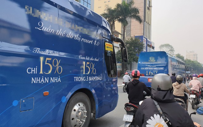 Hai chiếc xe khách quảng cáo cho một dự án bất động sản lưu thông trên đường Võ Thị Sáu, Q.3, TP.HCM. /// Ảnh: Sỹ Đông