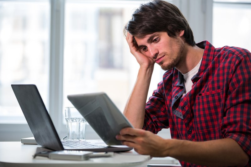 Male business executive looking at digital tablet in office