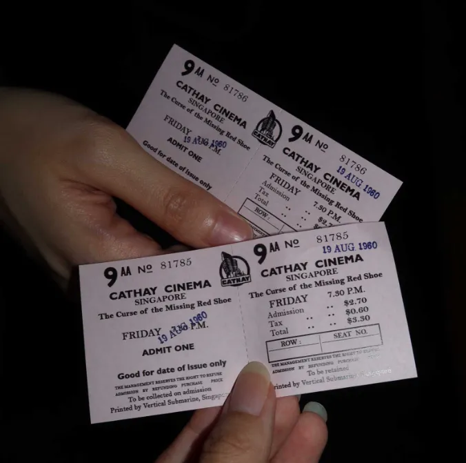 a person holding two tickets in their hand