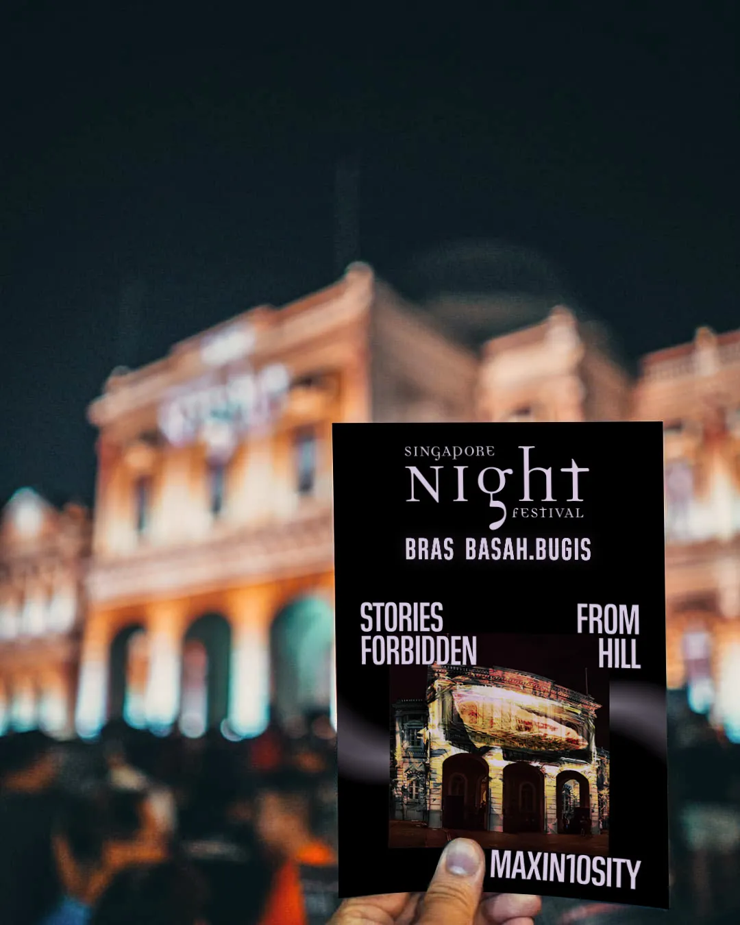 a person holding up a book in front of a building