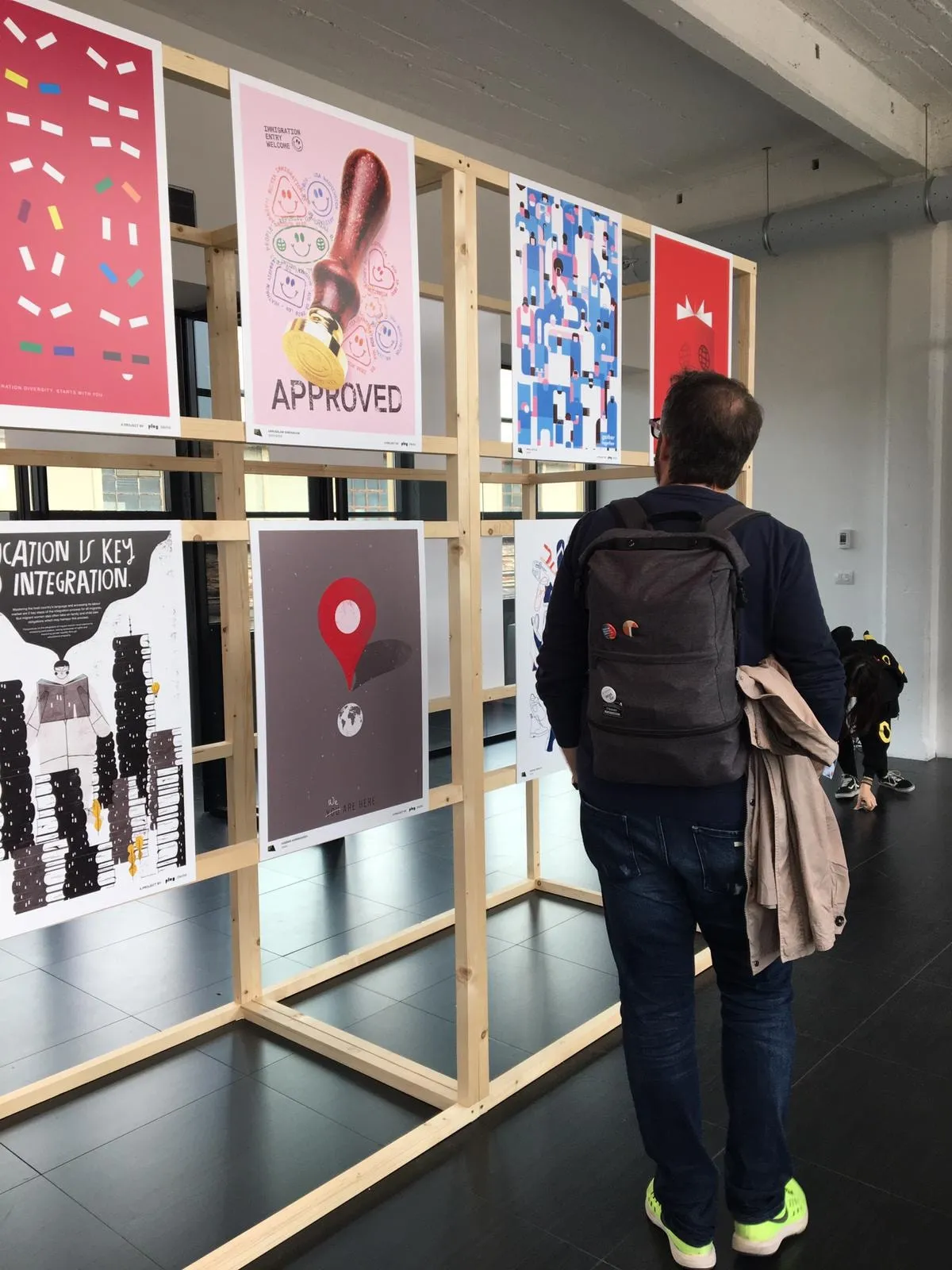 a man with a backpack is looking at art on display