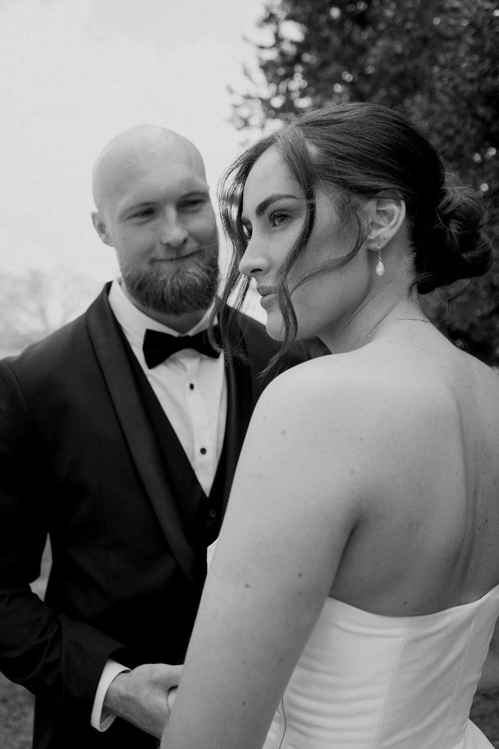 Groom looking at bride longingly during their wedding at the Red Barn Lake Karapiro