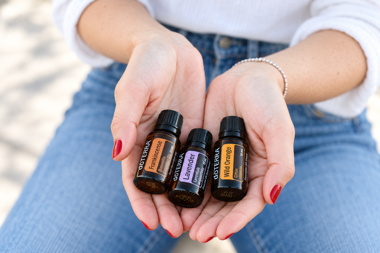 Frankincense, Lavender und Wild Orange von dōTERRA in zwei Händen