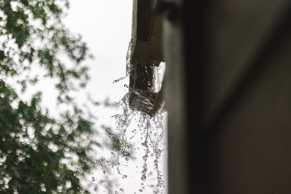 Rainwater running off a small home roof through a downspout