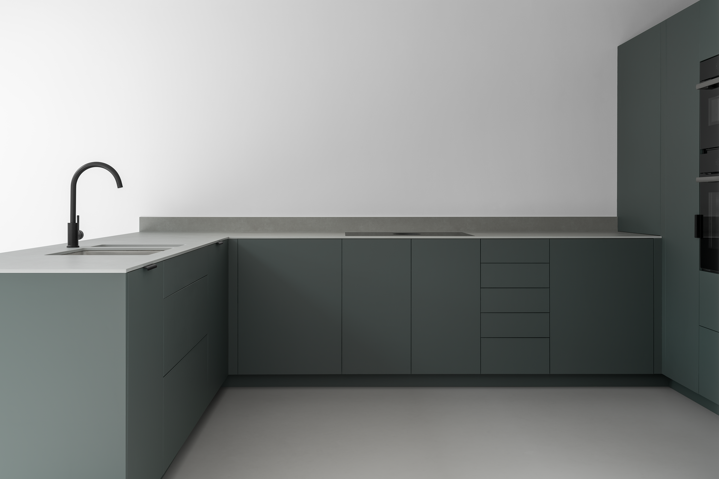 Modern ultra minimal Japanese style kitchen with white walls, grey resin floor, dark green-grey cabinets, slim textured grey stone work surface and black tap.