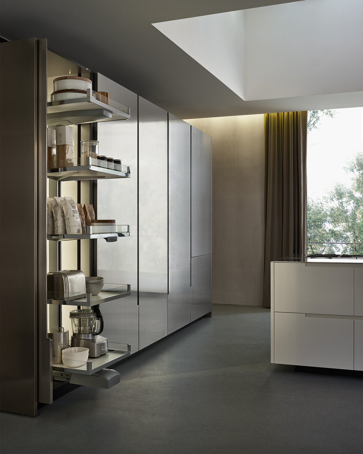 Minimal kitchen with metal doors by Poliform. Door folds into side of storage cabinet and shelves glide out.