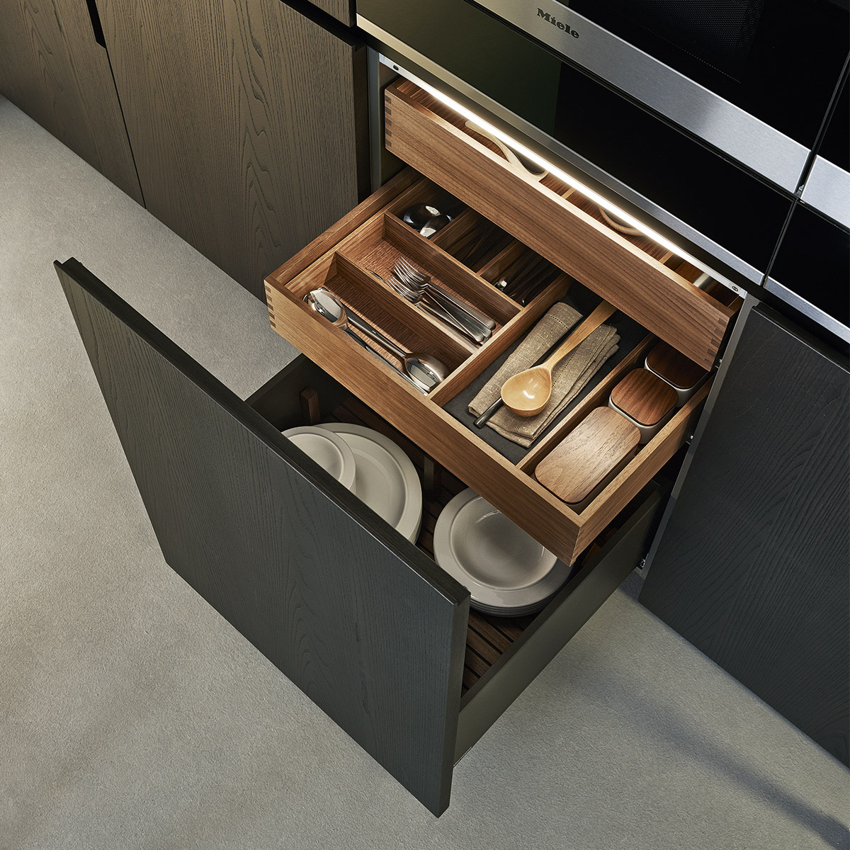 Black minimal kitchen with open lower level storage cabinet with hidden walnut wood drawers