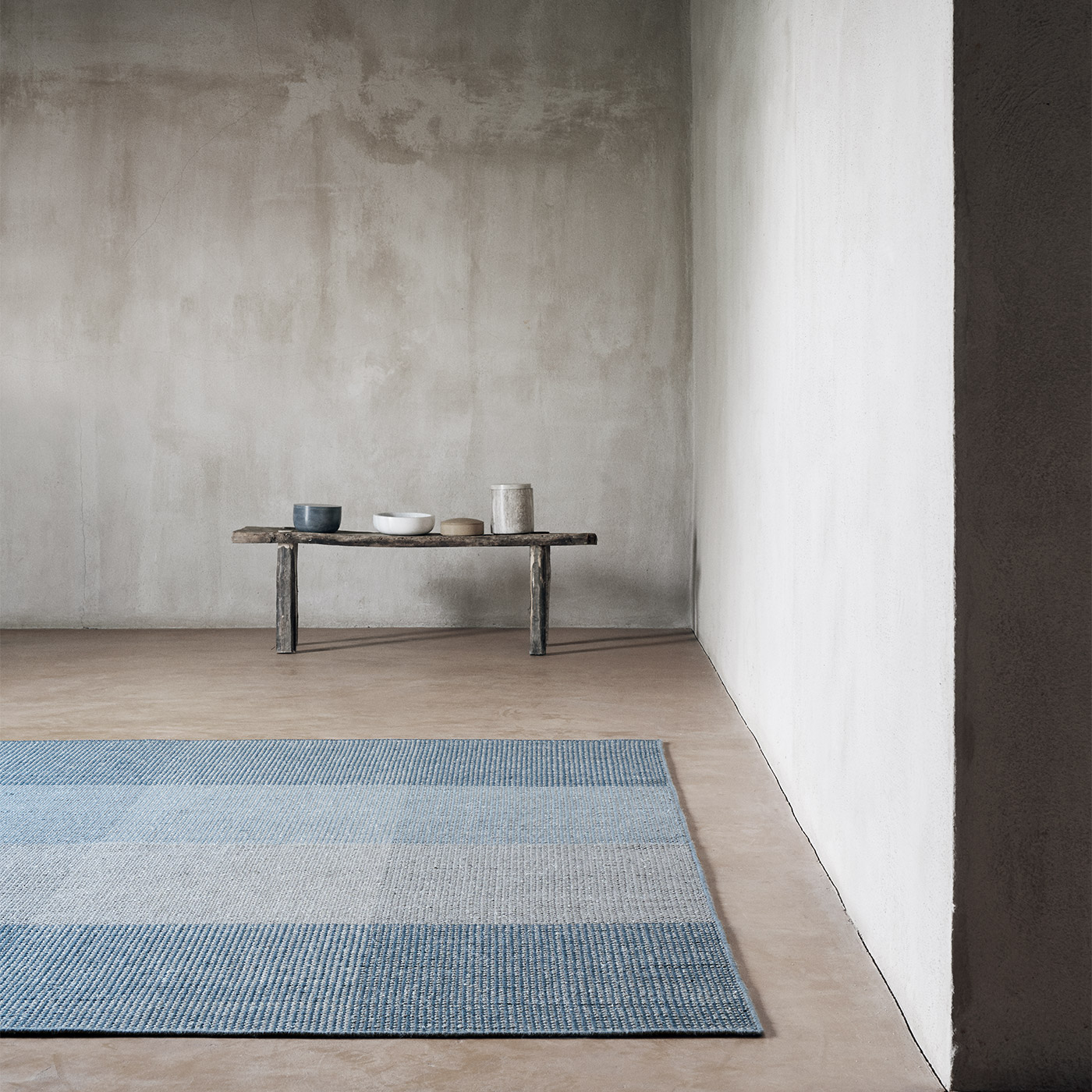 large blue grey geometric rug on concrete floor