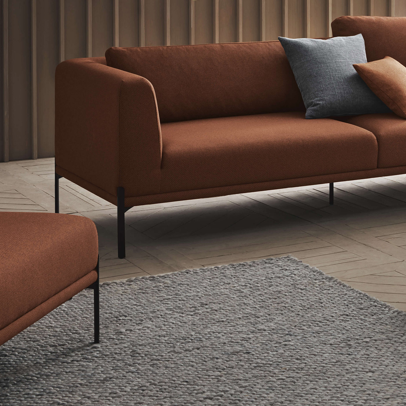 grey chunky woven wool rug and burnt orange sofa