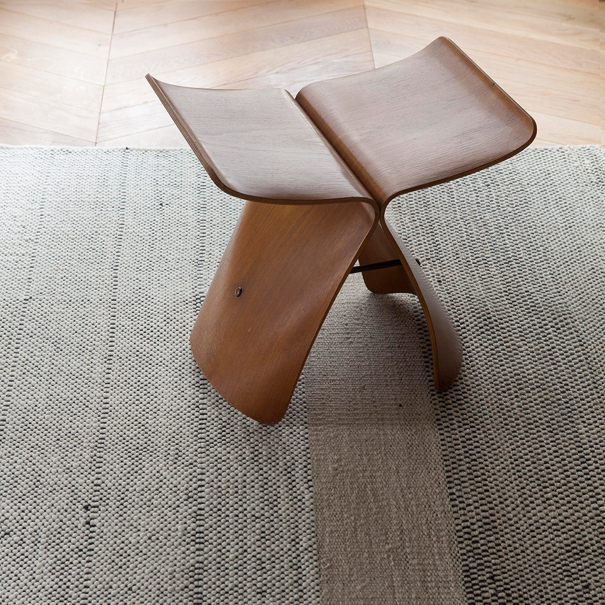 neutral textural rug with Japanese wooden stool