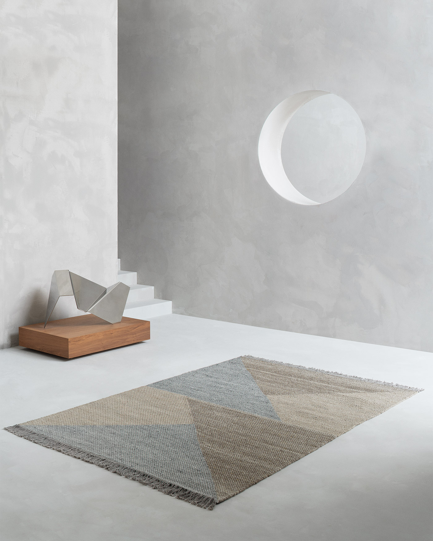 geometric flat wool rug on concrete floor with modern sculpture