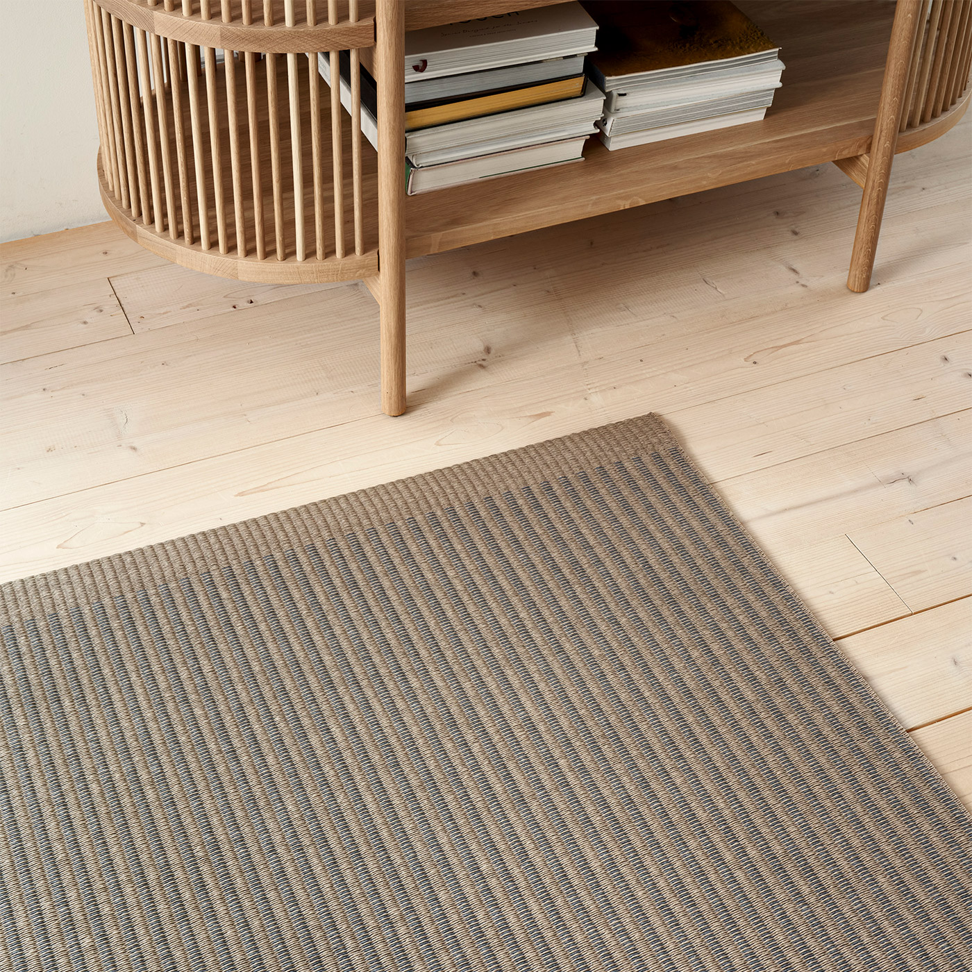 brown and grey paper yarn rug with Scandinavian wooden cupboard