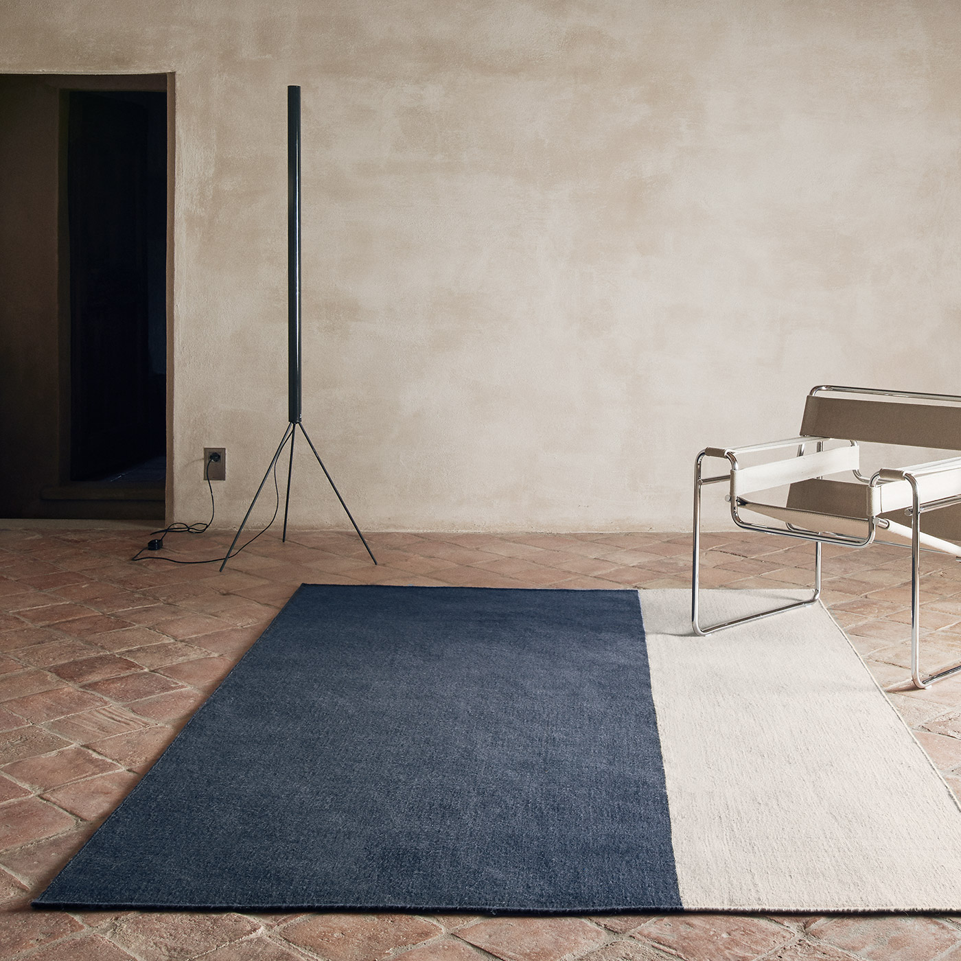 navy and cream two tone rug on rustic tiled floor with modern furniture