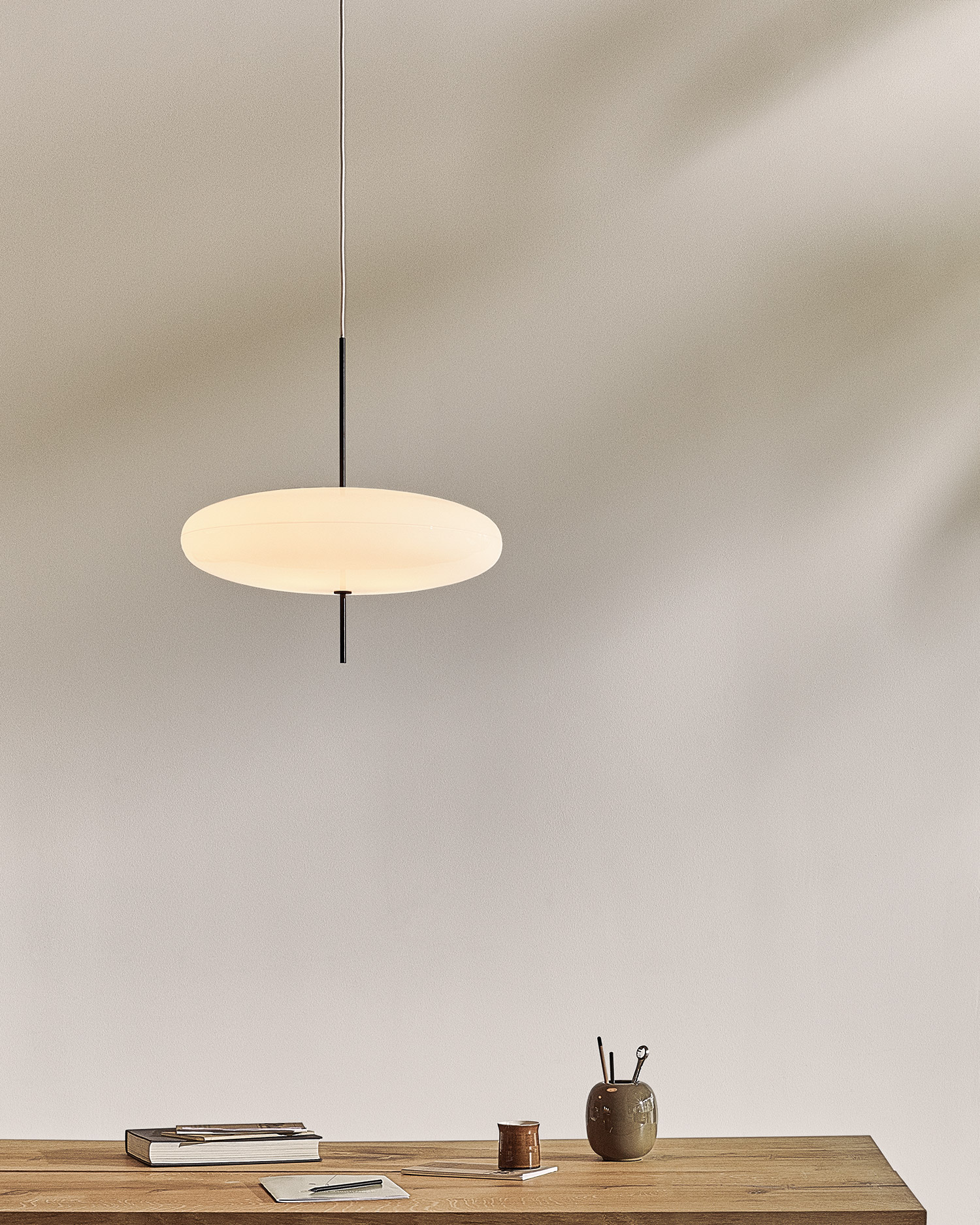 modern minimal pendant light over a wooden desk