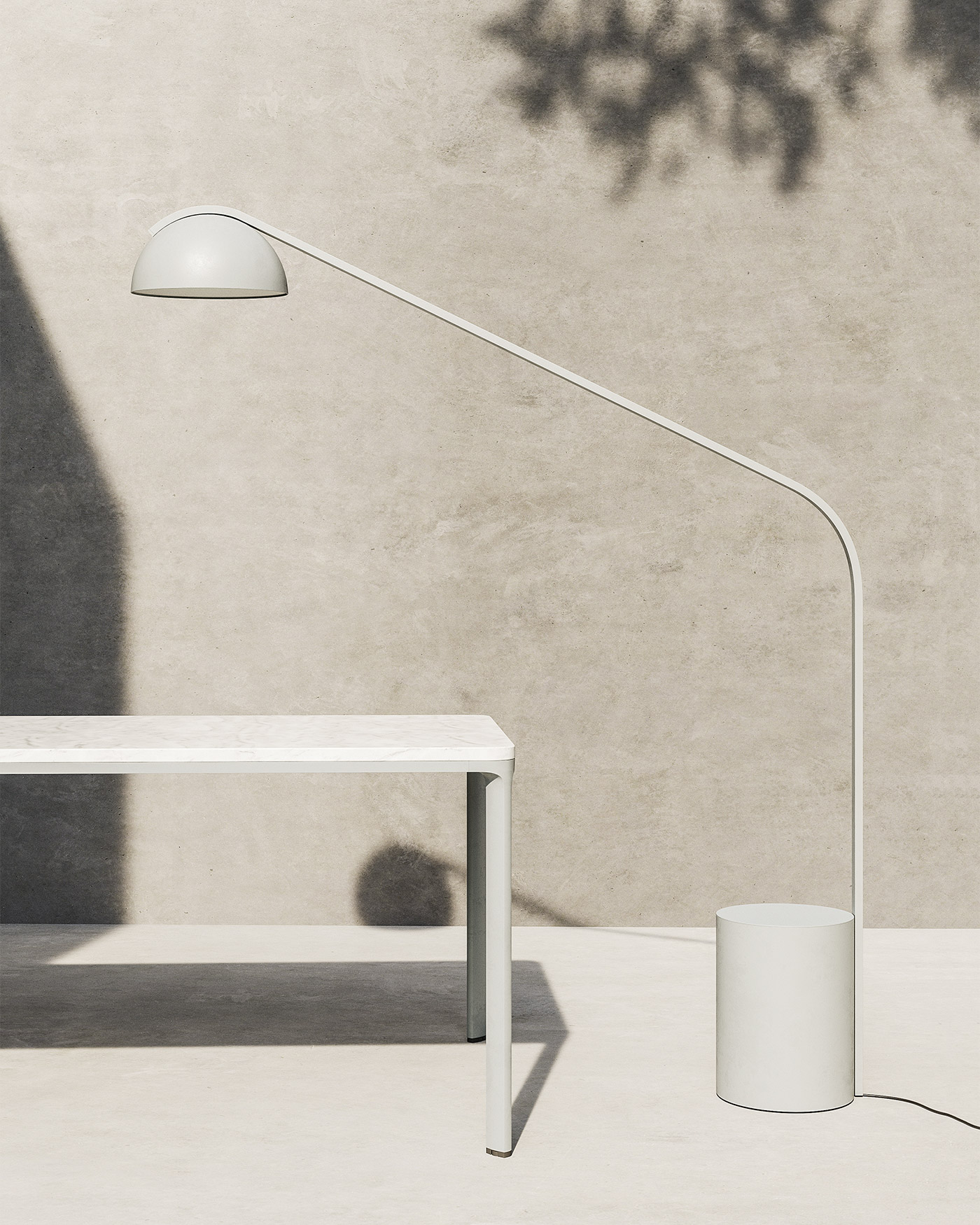Overhand Half Dome modern metal outdoor floor lamp in grey, metal and ceramic outdoor table with concrete wall and floor and sunlight