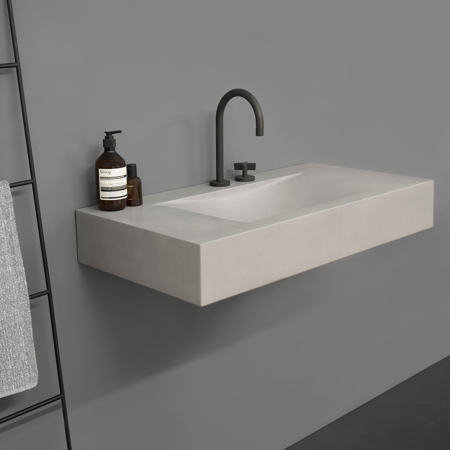 concrete hand basin and black metal mixer tap