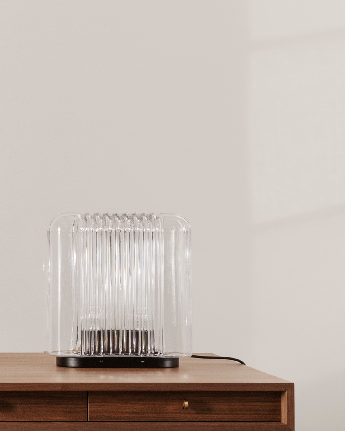 Lari glass table lamp by Karakter on wooden desk