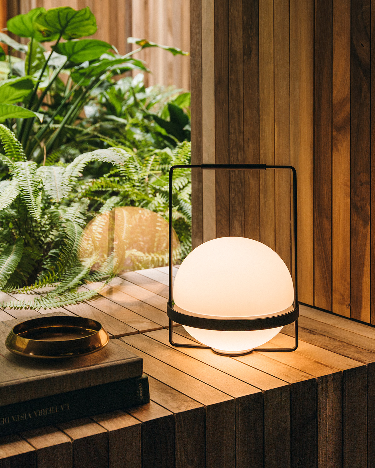 Palma table lamp by Vibia on modern wooden windowsill, background tropical plants