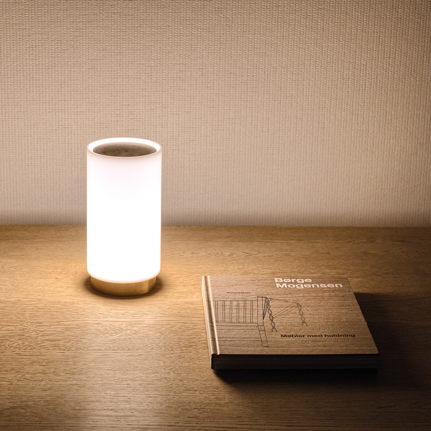 Bugia table lamp on wooden sideboard with mid-century furniture book