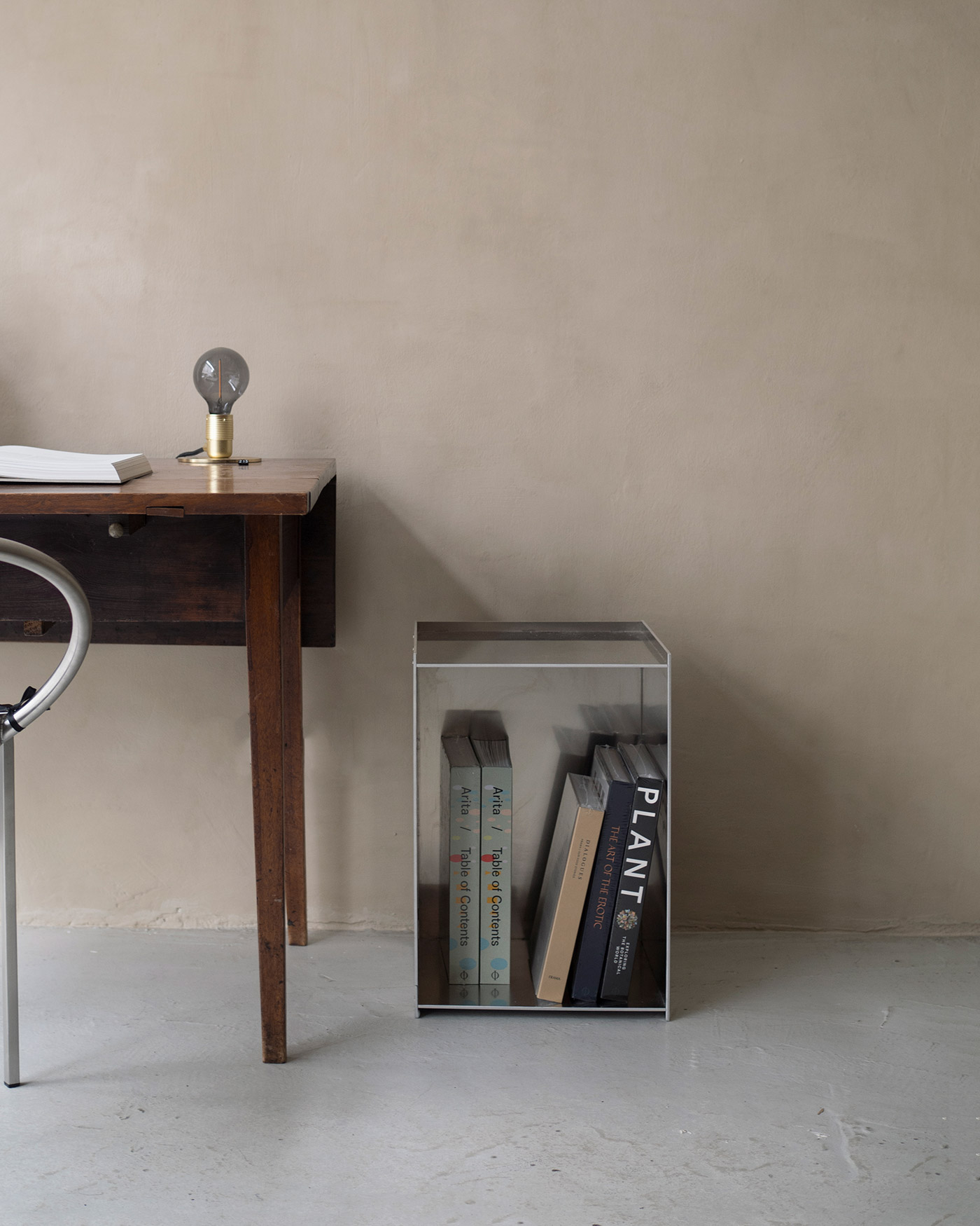 Rivet box table in sheet aluminium next to vintage wooden desk