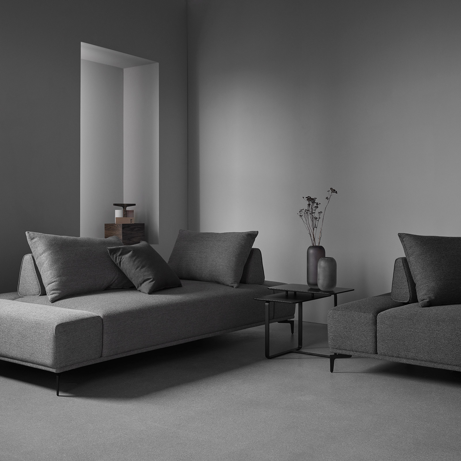 Define sofa by Wendelbo in dark grey fabric in grey minimal room