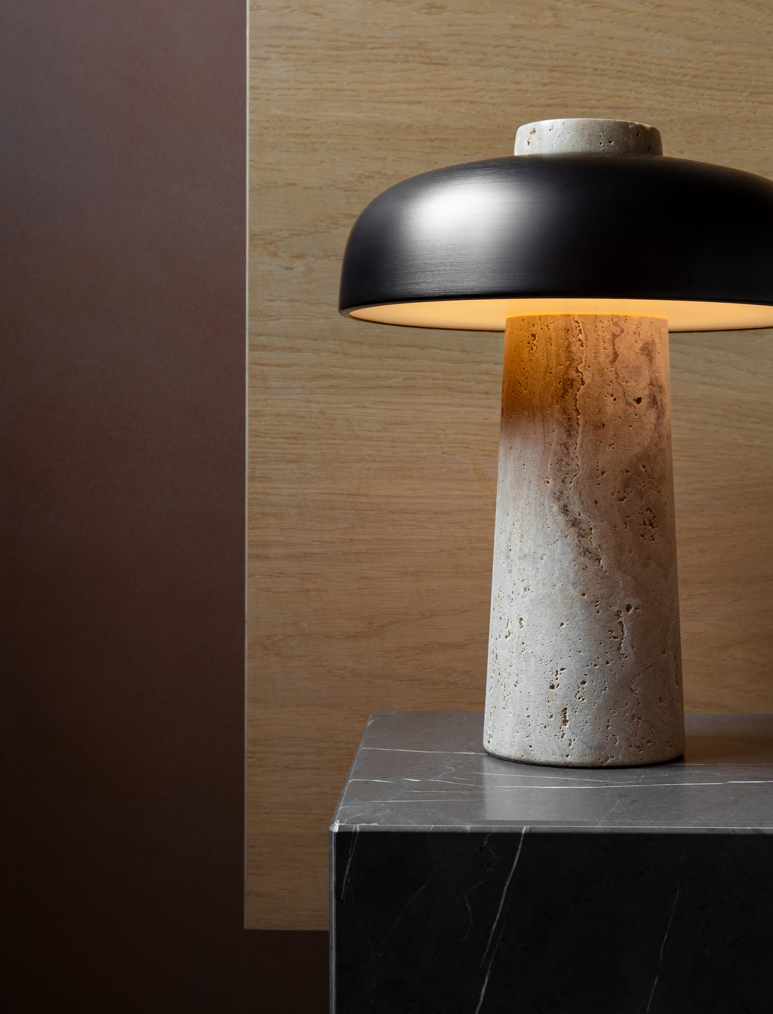 Reverse table lamp on marble plinth against oak headboard
