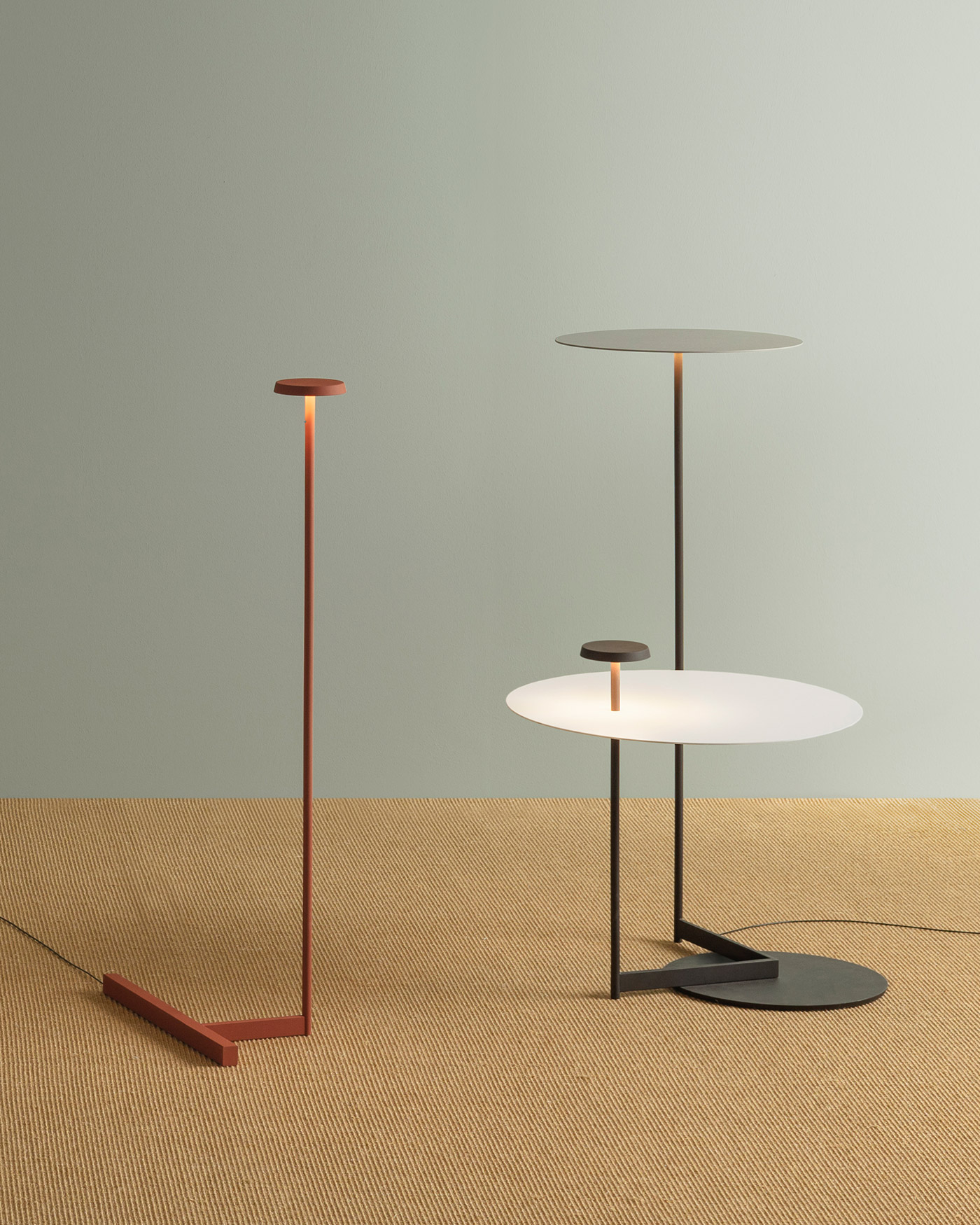 Flat floor lamps on sisal rug against grey green wall