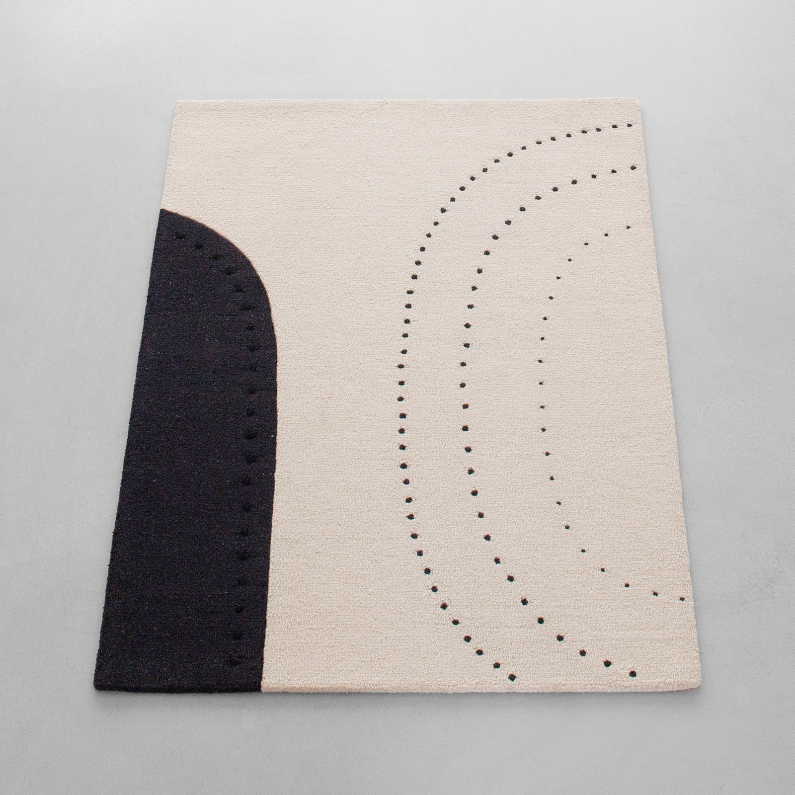 Dotted balance rug in cream and black on grey floor