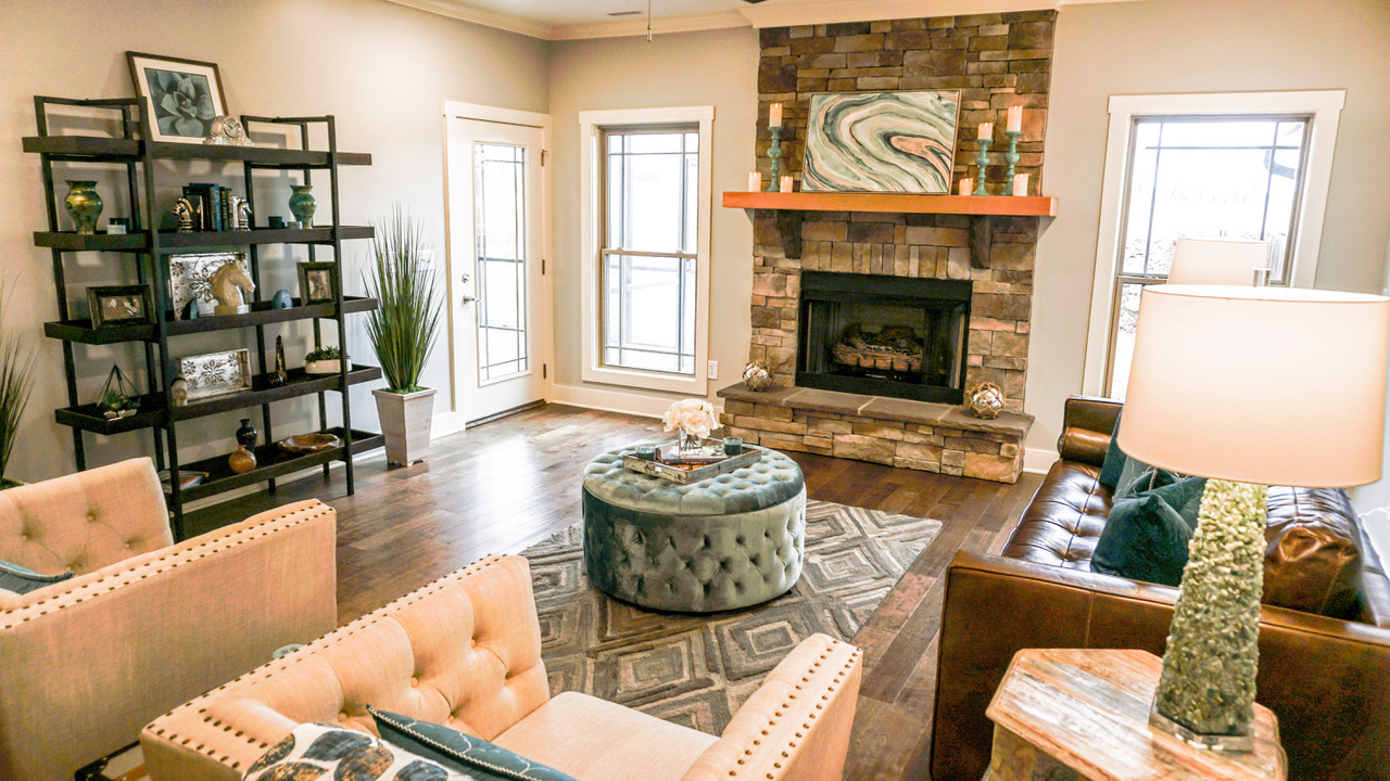 Alternative view of living room with couch, two chairs, fireplace, and decorations