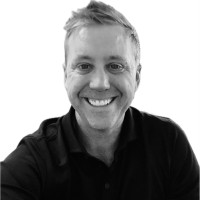 A headshot of Bradley against a plain white background wearing a black shirt.