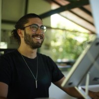 A picture of Sebastian Kresting on a boat, wearing a long sleeved t-shirt and glasses, with a Sebs characteristic ponytail.