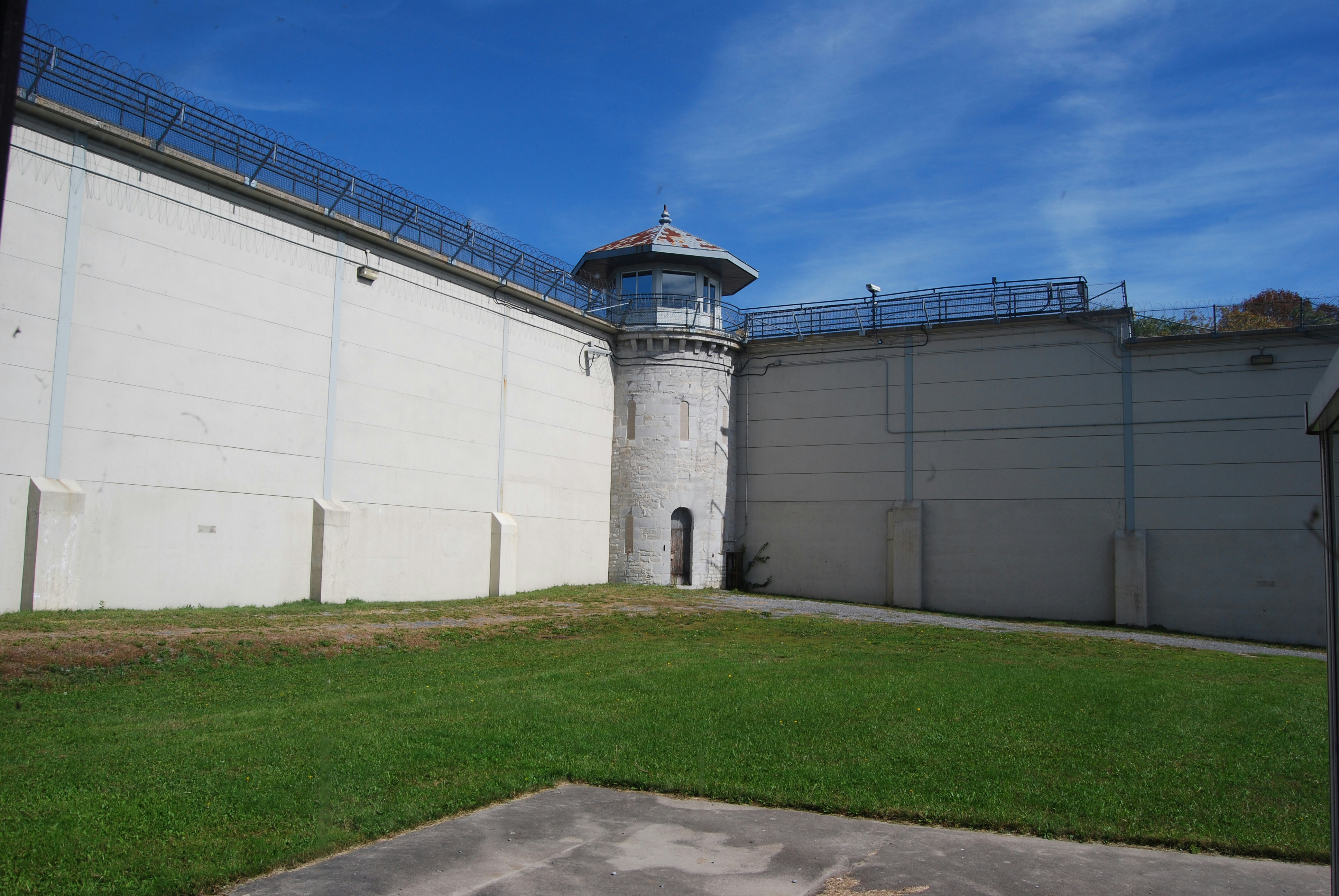 prison yard with watchtower and fenced perimeter