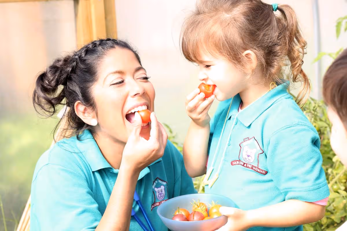photo of a child and child-minder eating tomatoes