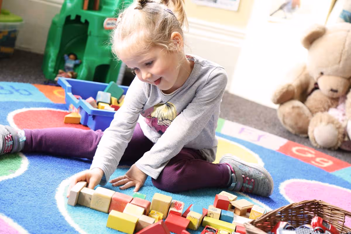 photo of child playing with building bricks