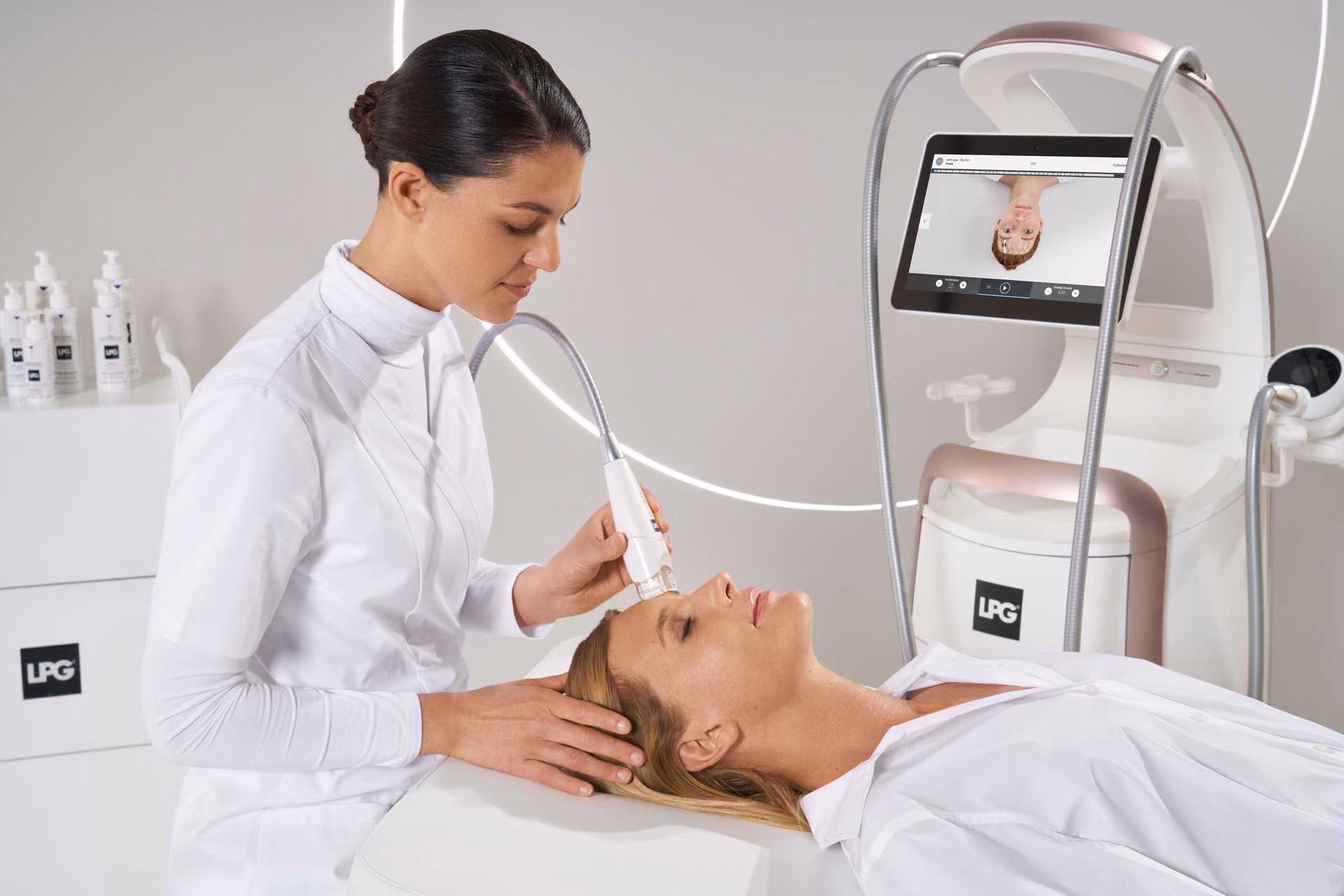 Woman receiving facial treatment with a handheld device by a professional in a medical spa setting.