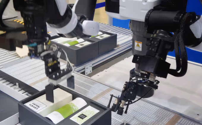Zwei sensorgestützte Cobot-Greifarme im Einsatz an einer Fertigungslinie
