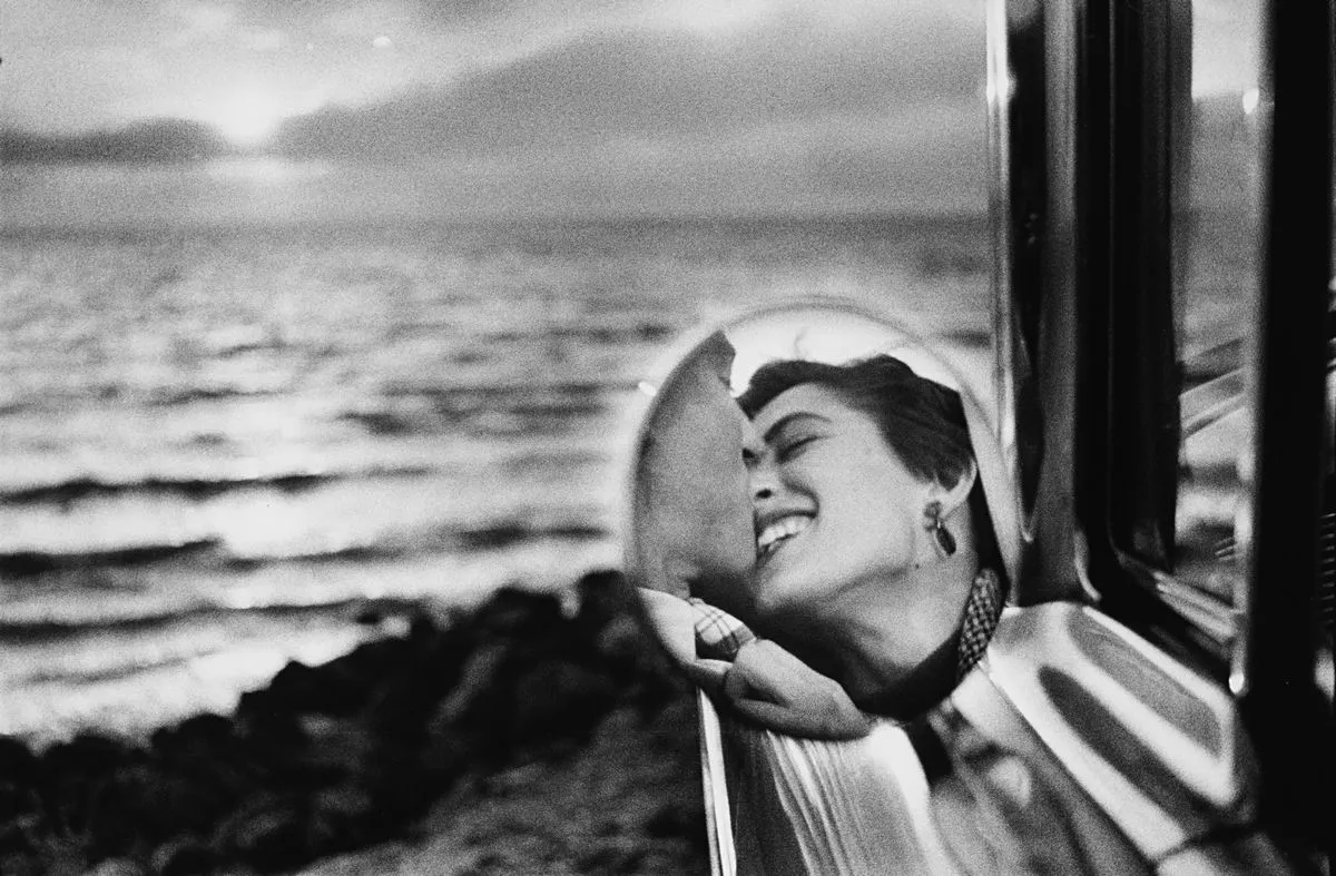 Bacio riflesso nello specchietto dell’auto, foto California Kiss di Elliott Erwitt
