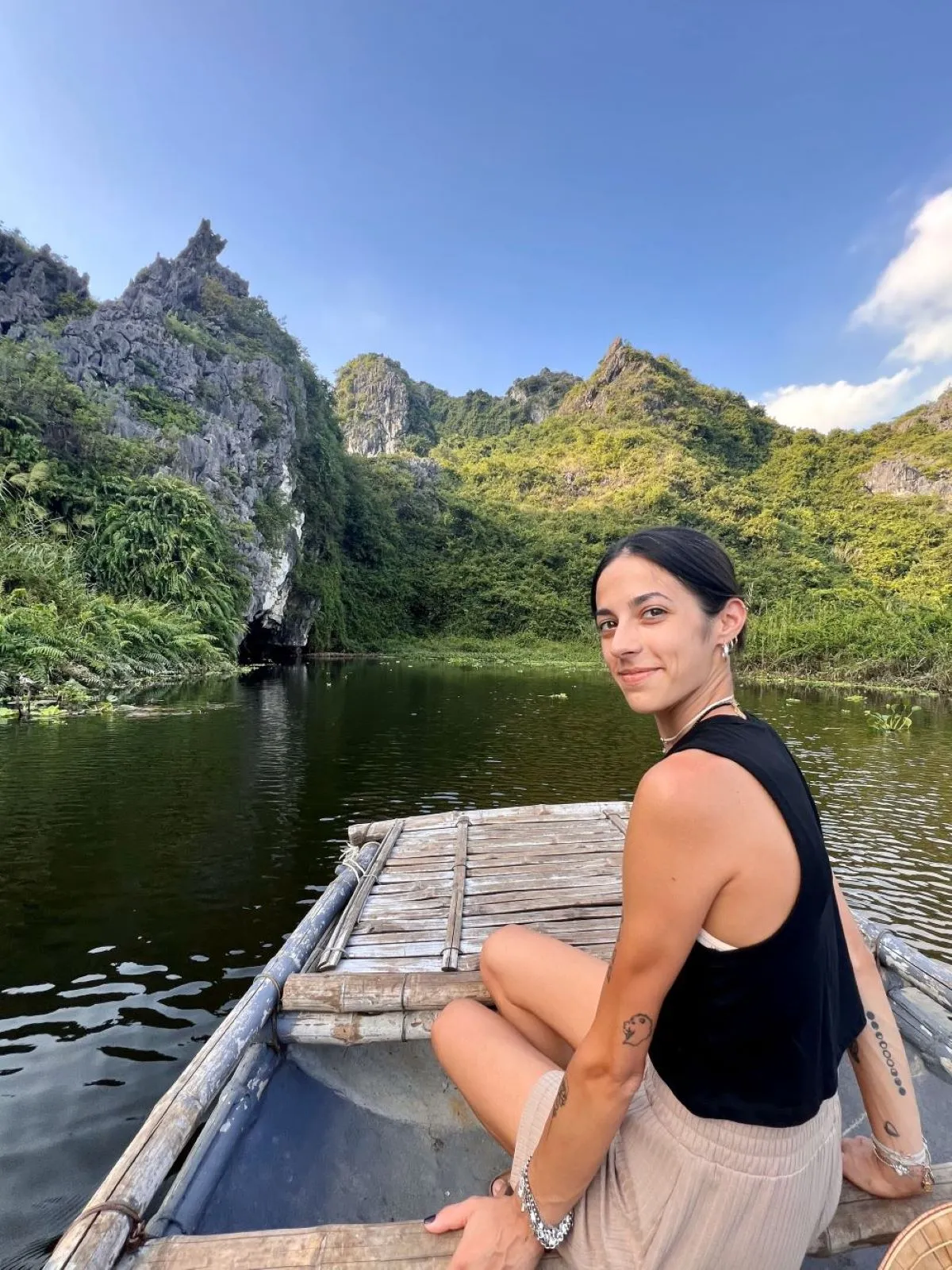 Jennifer Amadei in barca tra le montagne rocciose del Vietnam, immersa in un paesaggio naturale mozzafiato e contemplativo