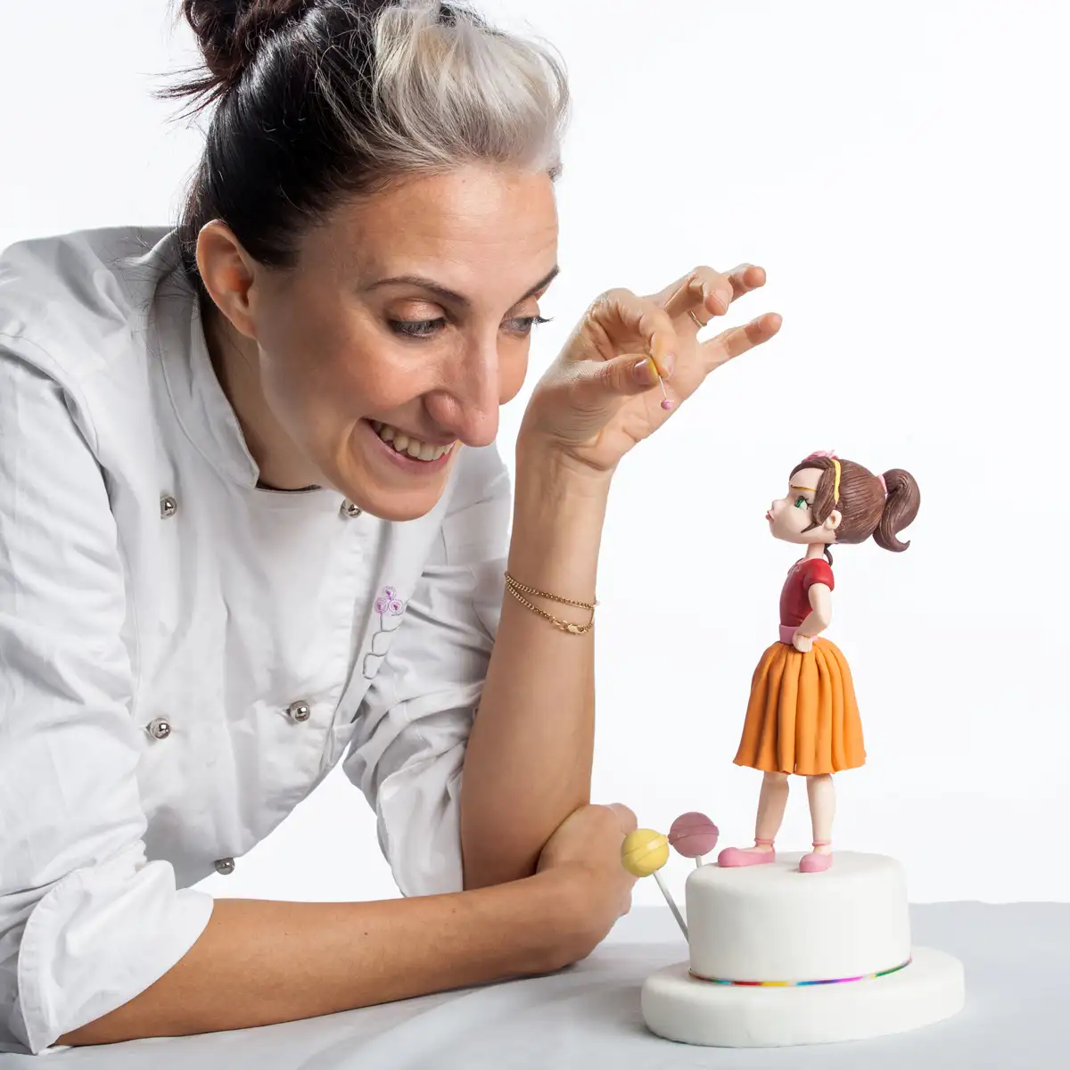 Silvia Mancini mentre modella un personaggio in pasta di zucchero su una torta artistica
