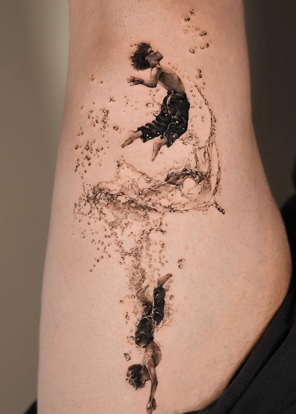 Tatuaggio microrealismo 3D di un ragazzo che emerge e si immerge nell’acqua, dettagli iperrealistici e dinamici