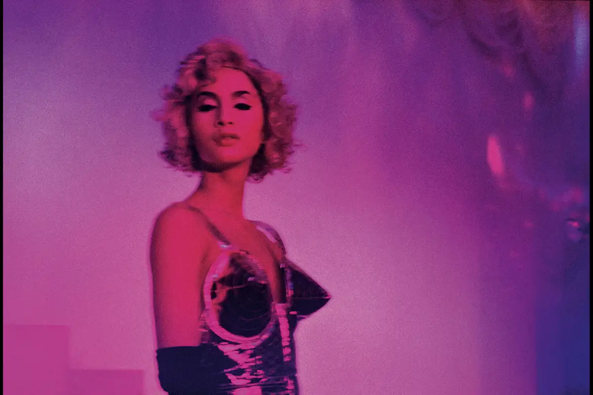 Performer in look alla Madonna, luci magenta; fotografia di Nan Goldin (1992), in mostra a HangarBicocca