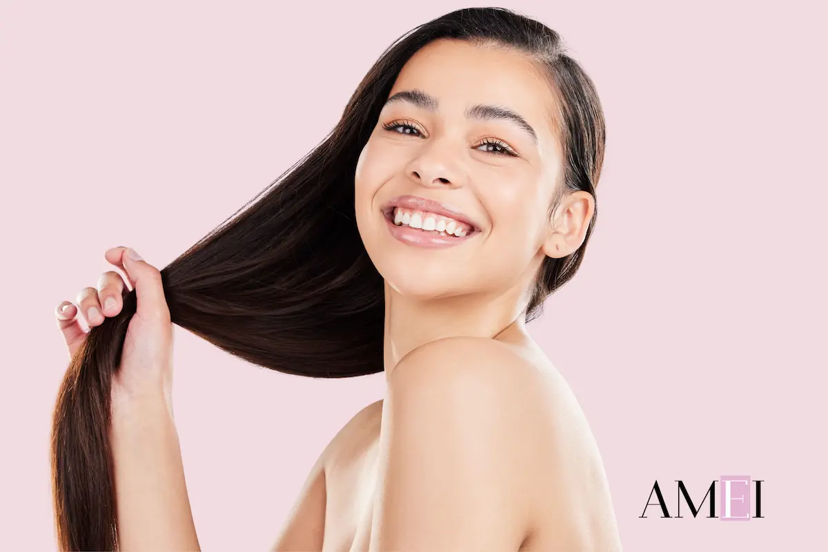 Donna sorridente con capelli lunghi e lucidi dopo routine di cura post vacanze, esempio di capelli sani e idratati.