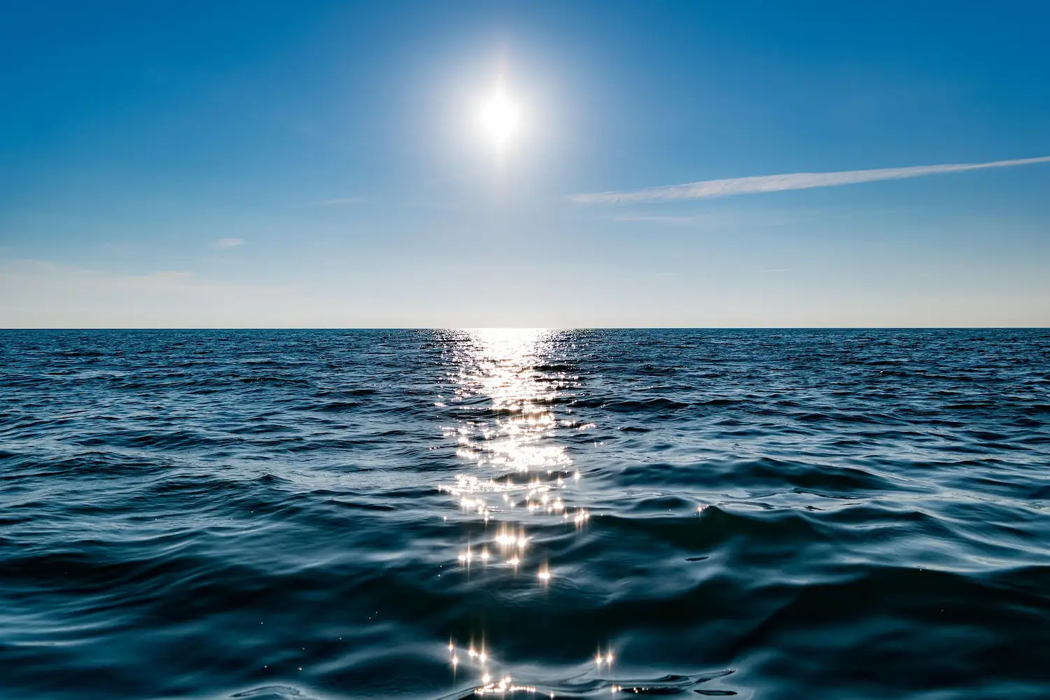 Riflesso del sole sull’acqua blu del mare, immagine calmante che evoca i benefici degli spazi blu sulla salute mentale