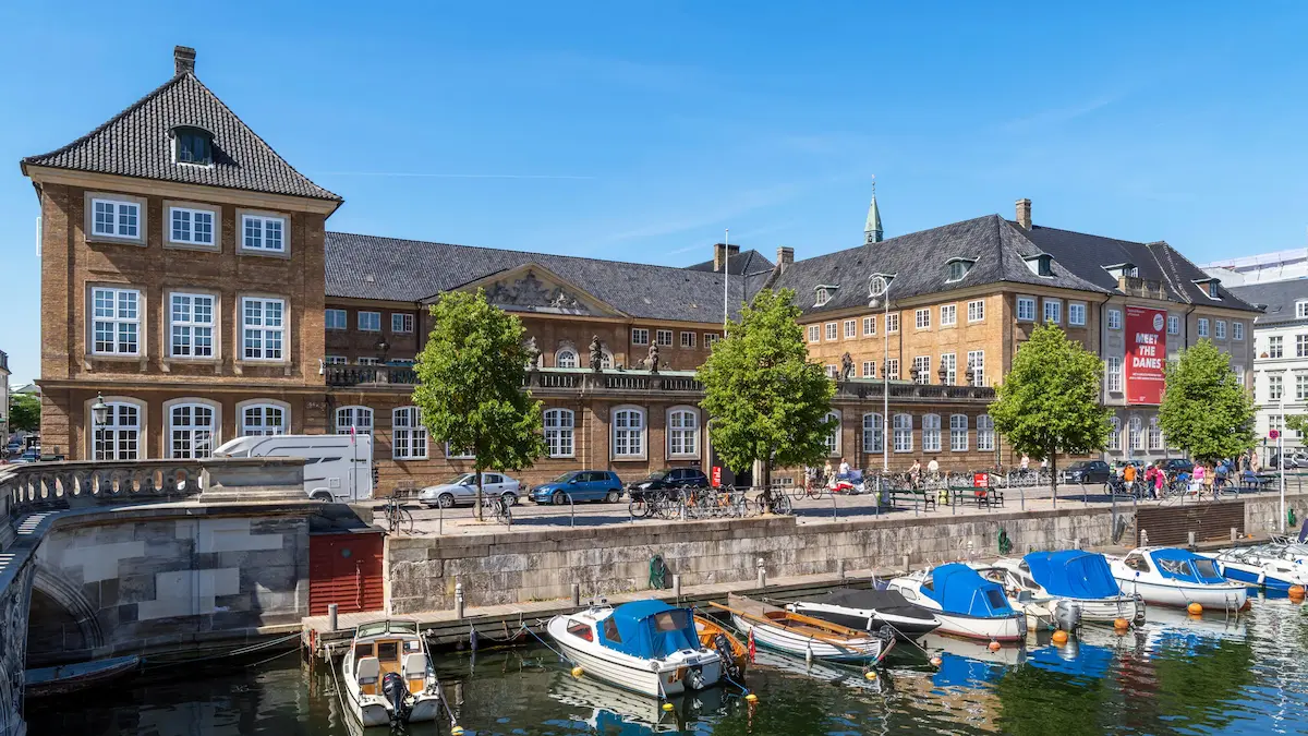 Facciata del Museo Nazionale di Danimarca a Copenaghen, affacciata sul canale con barche ormeggiate.