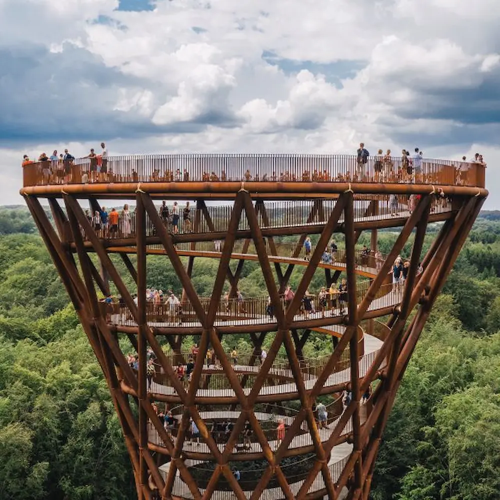 Torre panoramica Forest Tower nella foresta danese Gisselfeld, spirale di legno tra gli alberi.