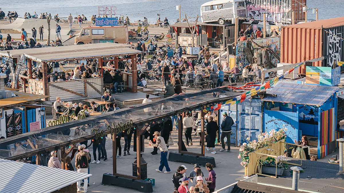 Reffen a Copenaghen, street food market all'aperto con container colorati, food truck e persone in relax.
