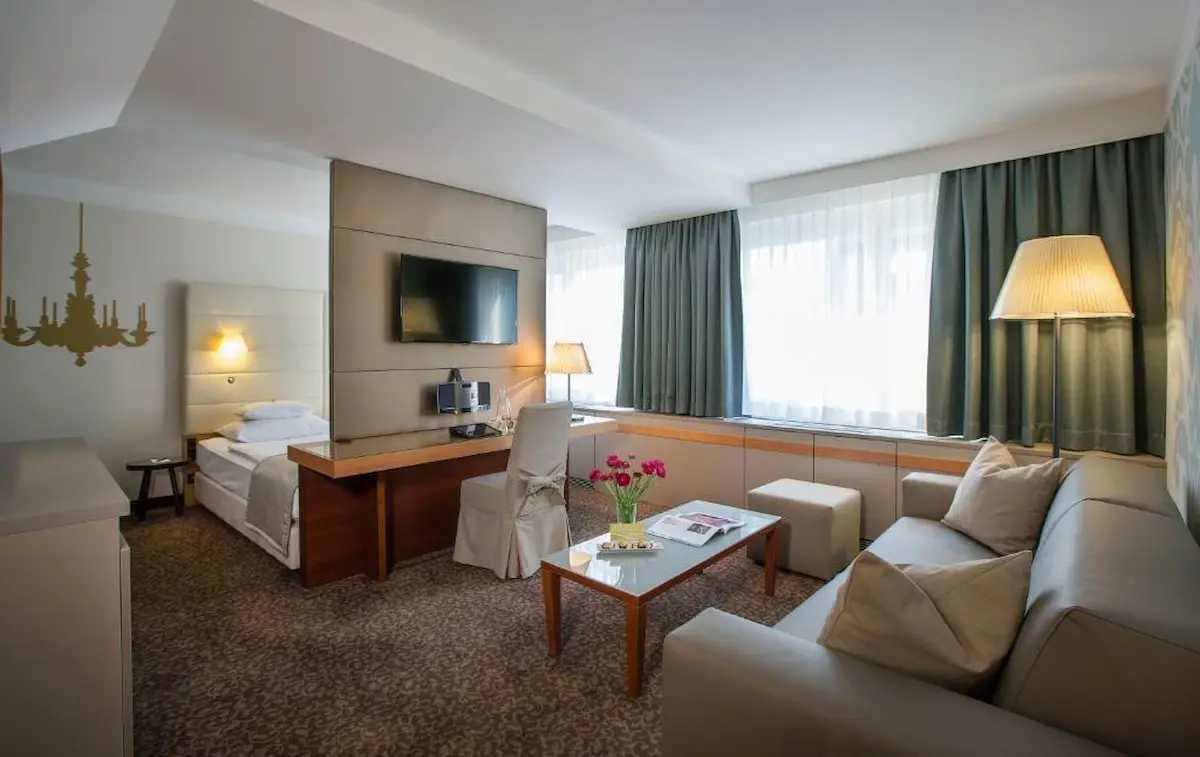 Camera luminosa dell’hotel Das Tigra a Vienna con zona letto, scrivania, divano e arredi dai toni neutri