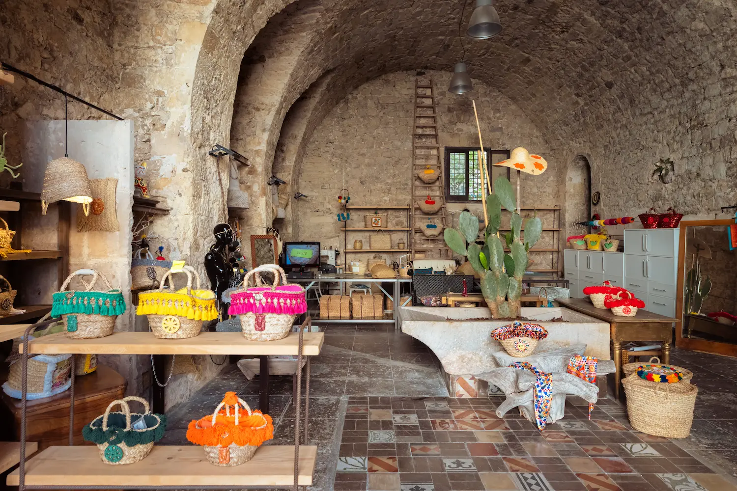 Interno dell’Officina & Boutique Danié Made in Sicily a Ragusa Ibla, con coffe artigianali siciliane esposte tra archi in pietra