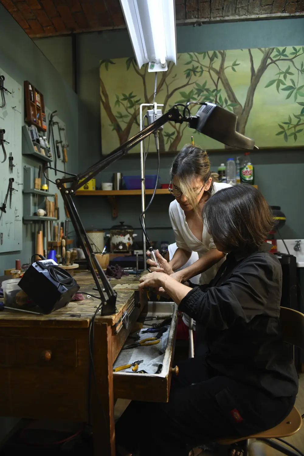 Elena e Isabel Moncada lavorano insieme a un gioiello nel laboratorio di CUATA Jewelry in Messico