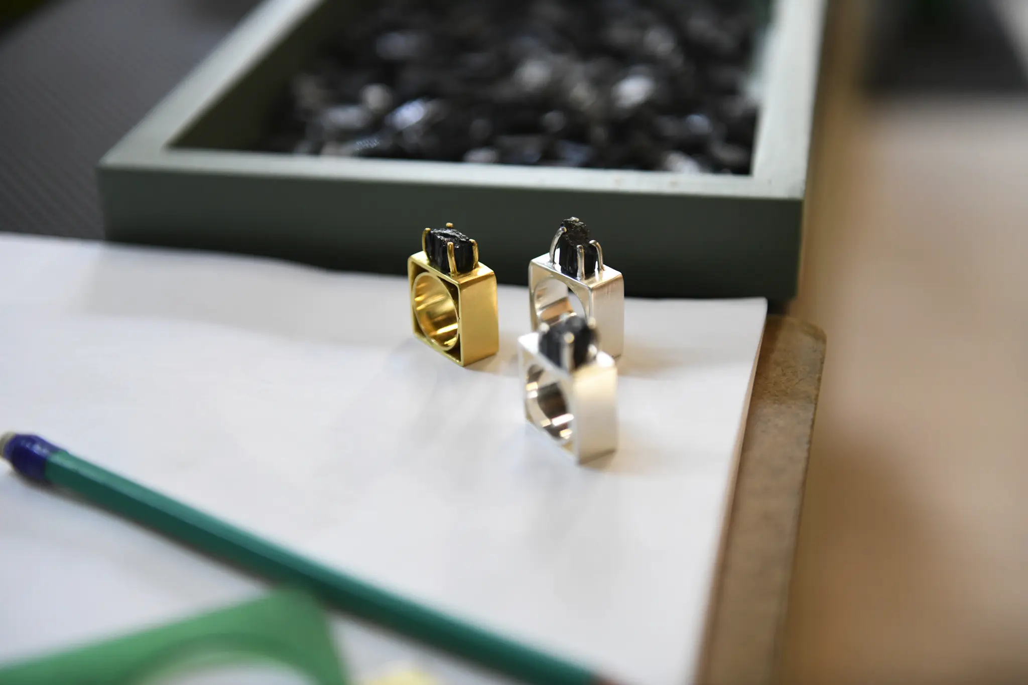 Anelli dal design geometrico di CUATA Jewelry sul tavolo di progettazione nel laboratorio in Messico